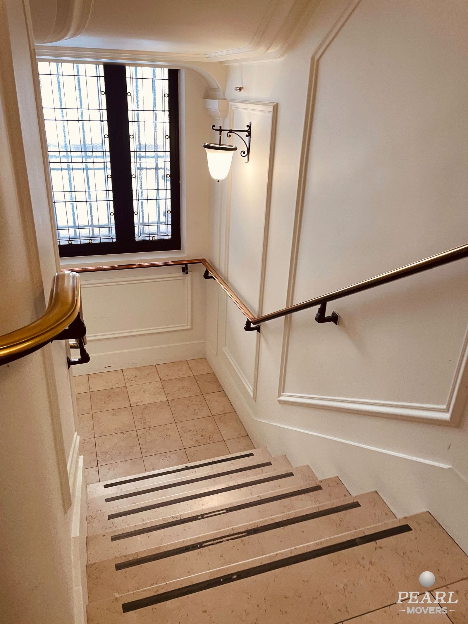 Staircase inside an older apartment building with wooden rails and a switchback landing